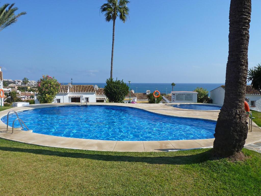 una gran piscina en un patio con una palmera en Holiday Home Las Buganvillas by Interhome, en La Cala de Mijas