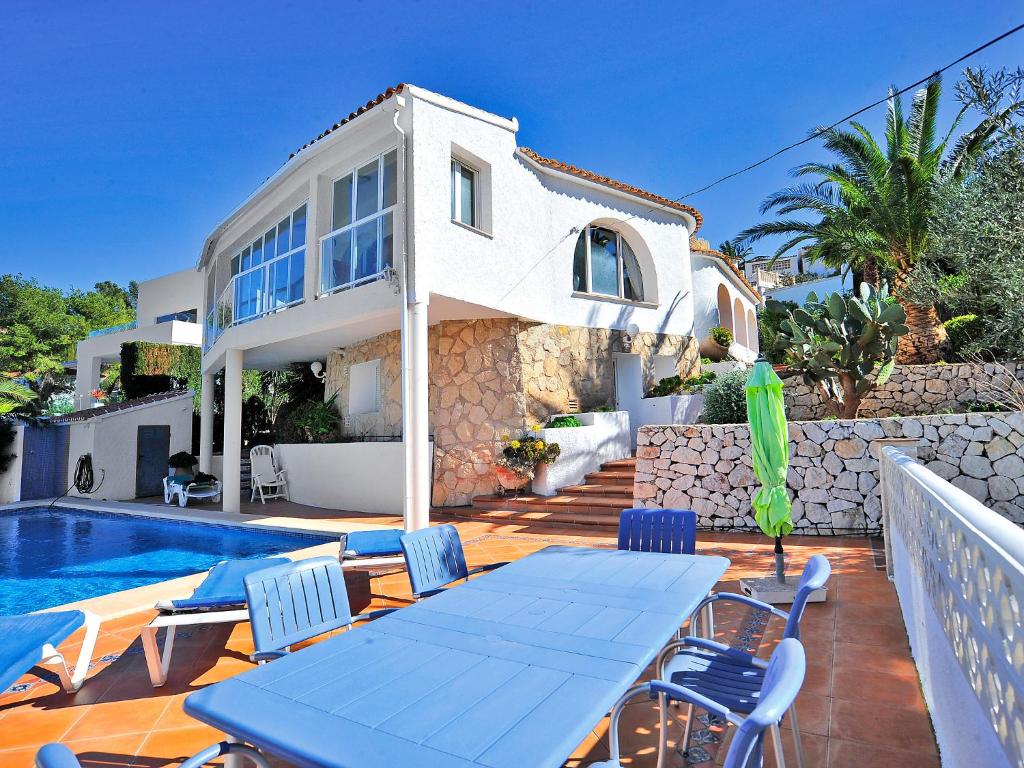 a house with a table and chairs next to a swimming pool at Holiday Home Balcon Al Mar by Interhome in Balcon del Mar