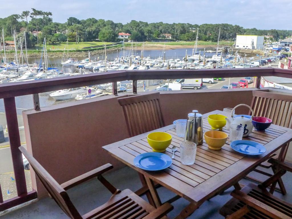 a table on a balcony with a view of a marina at Apartment mille sabords-6 by Interhome in Capbreton