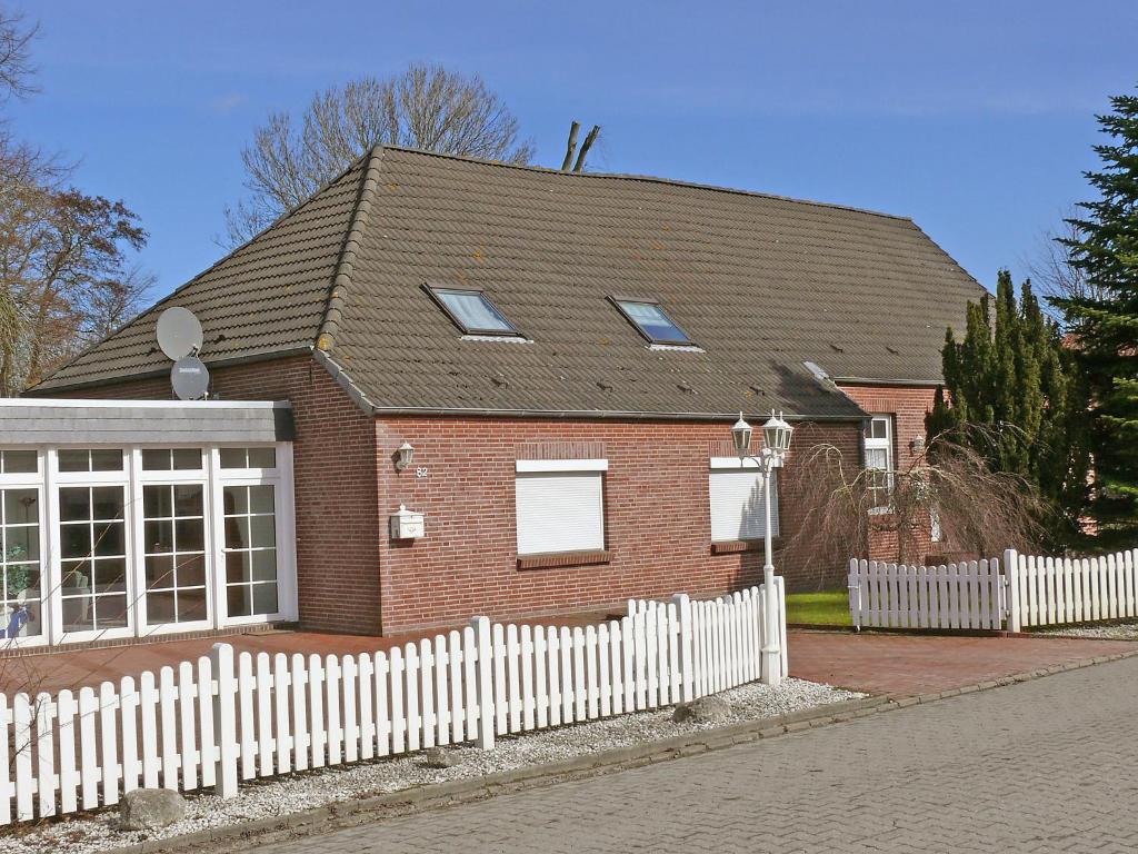 une maison en briques rouges avec une clôture blanche dans l'établissement Holiday Home Reithammer Weg by Interhome, à Kreitlapperei