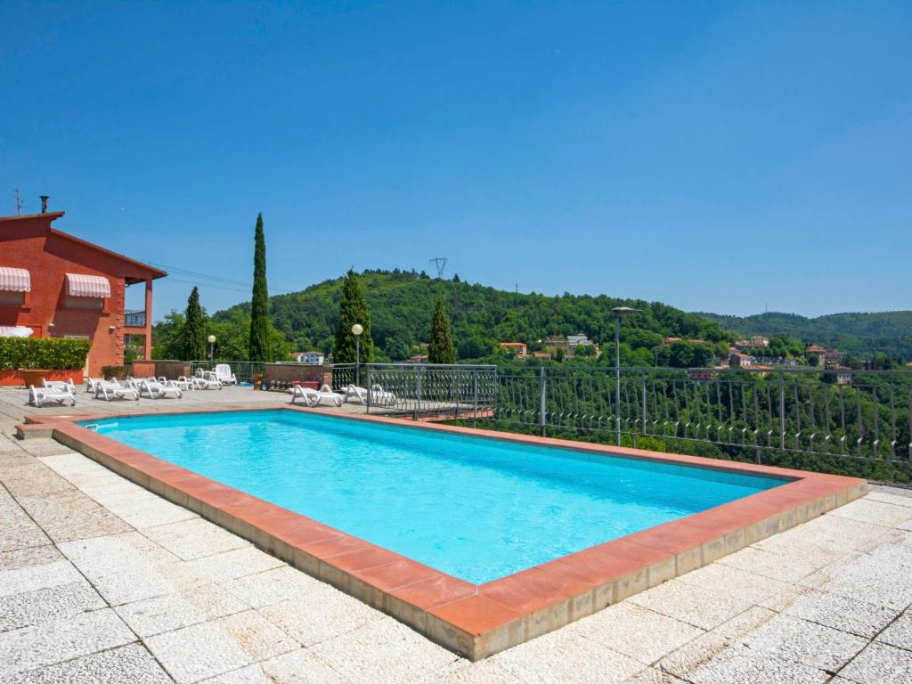 a swimming pool with blue water in a resort at Apartment Il Cipresso by Interhome in San Baronto