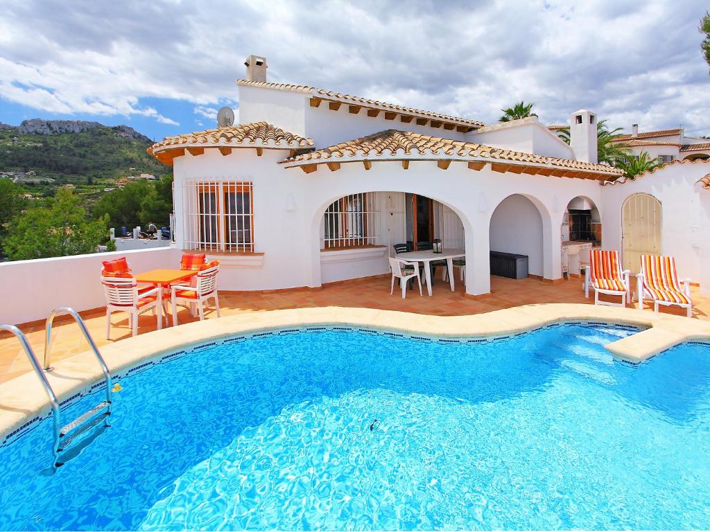a villa with a swimming pool in front of a house at Holiday Home Monte y Mar by Interhome in Monte Pego