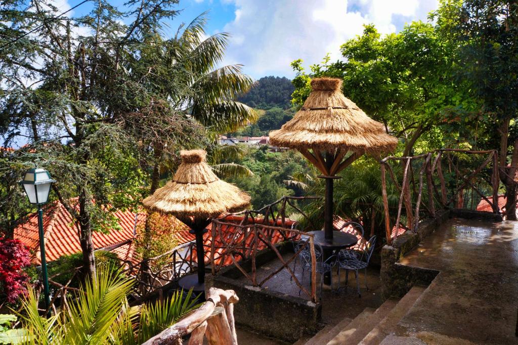 twee rieten parasols op de patio bij Casas de Campo do Pomar B&B - Self Check-in in Santana