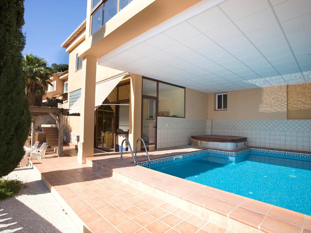 a swimming pool in front of a house at Apartment Raquel by Interhome in Calpe