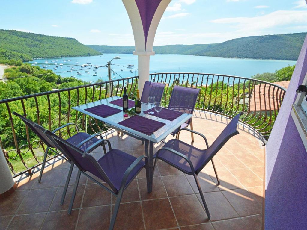 a table and chairs on a balcony with a view of a lake at Apartment Šverko by Interhome in Trget