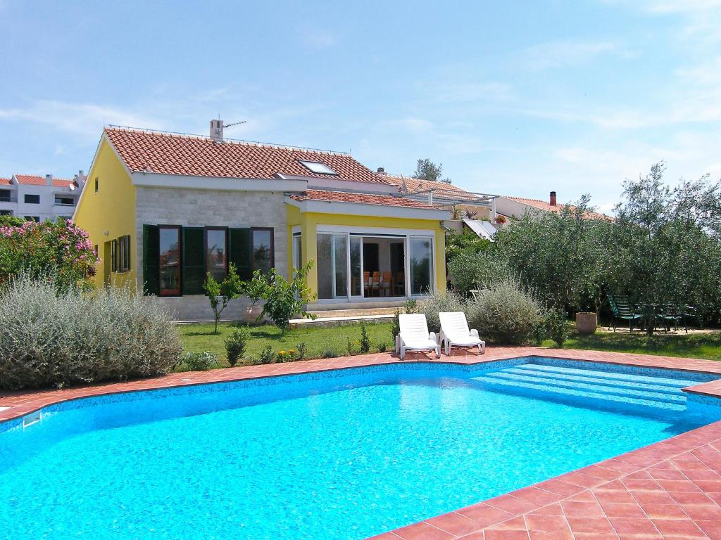 - une piscine en face d'une maison dans l'établissement Villa Yellow House by Interhome, à Diklo