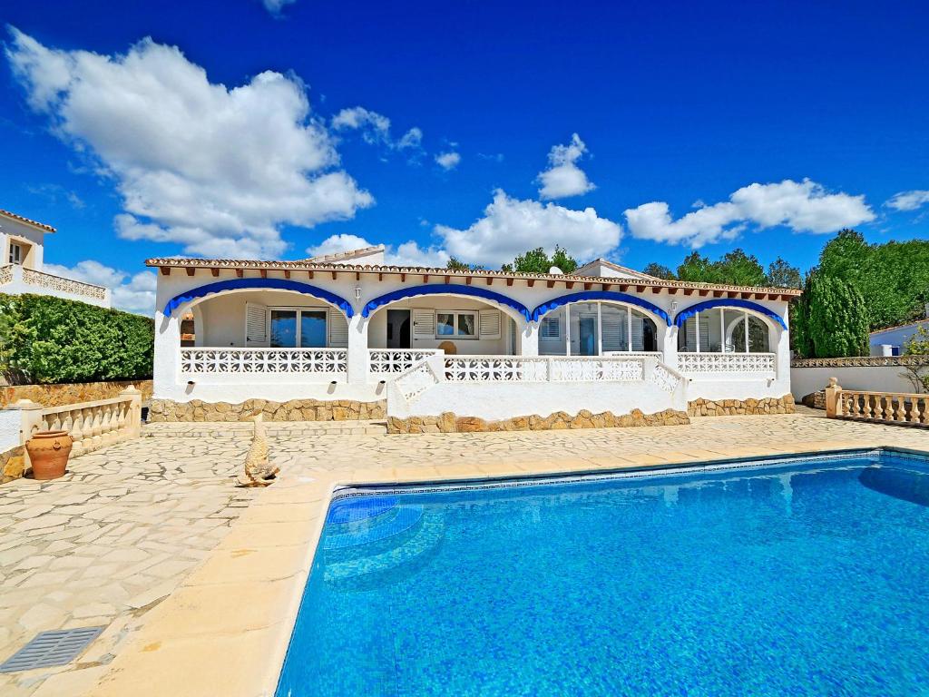 a villa with a swimming pool in front of a house at Holiday Home La Sabatera by Interhome in Moraira