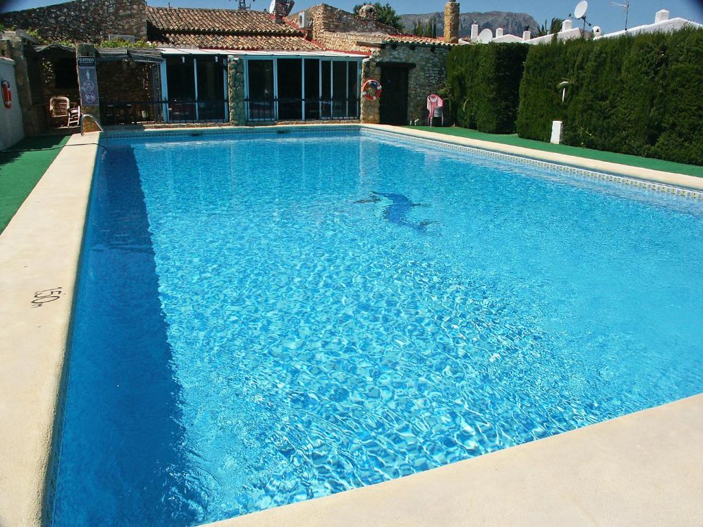 a large blue swimming pool in front of a house at Holiday Home Etxe Zuri by Interhome in Calpe