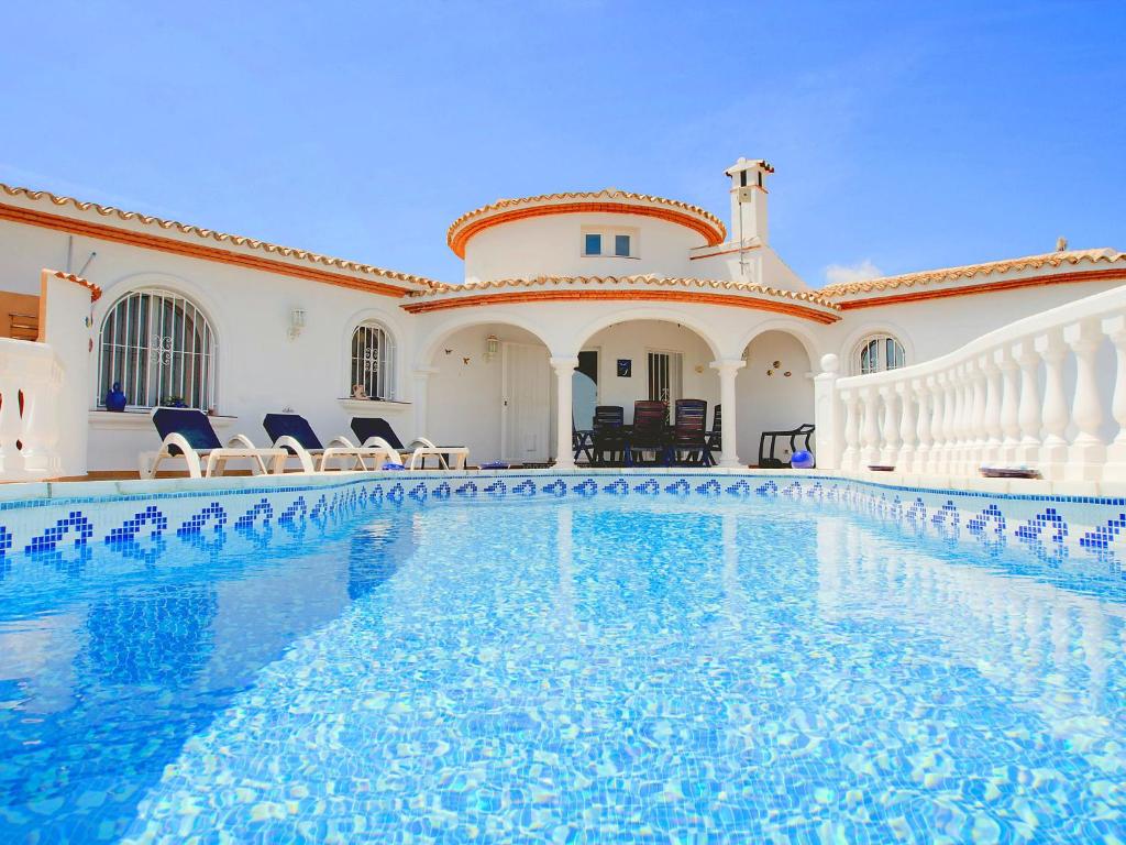 una piscina en una casa con sillas y un edificio en Villa Ma-Nita by Interhome, en Monte Pego