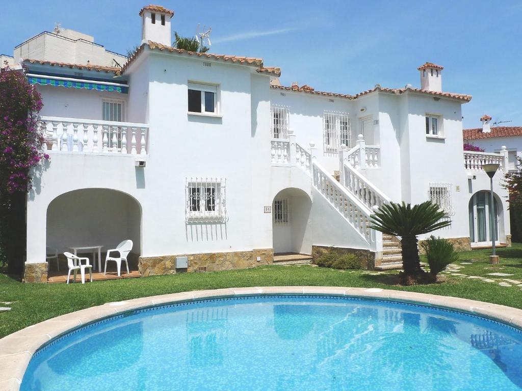 une villa avec une piscine en face d'une maison dans l'établissement Apartment Club Sevilla I by Interhome, à Casas Devesa