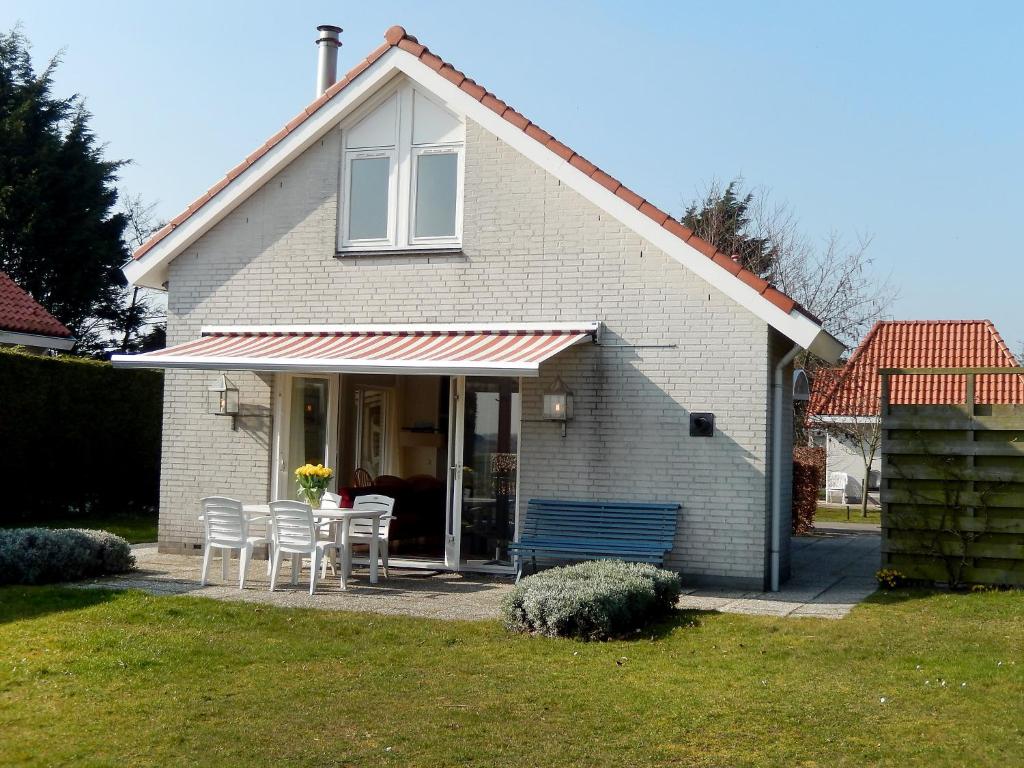 una casa con mesa y sillas en un patio en Holiday Home Stern Comfort by Interhome, en Noordwijk