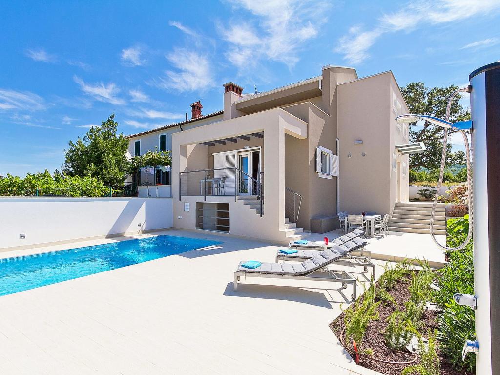 a villa with a swimming pool and a house at Holiday Home Elena by Interhome in Raša