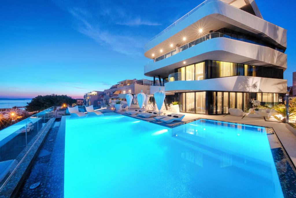 un hotel con piscina frente a un edificio en Posh Residence Luxury Suites, en Split