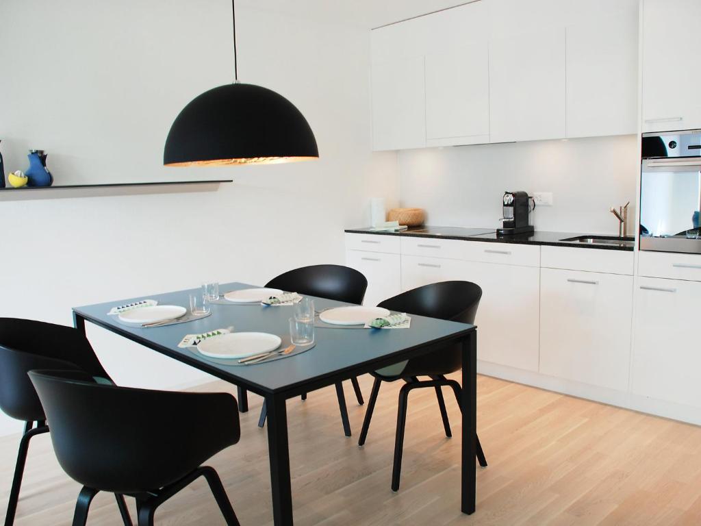 a dining room table with black chairs in a kitchen at Apartment LaVille A-4-3 by Interhome in Locarno