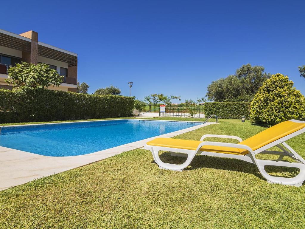 a yellow lounge chair sitting next to a swimming pool at Apartment Valérie by Interhome in Benfarras