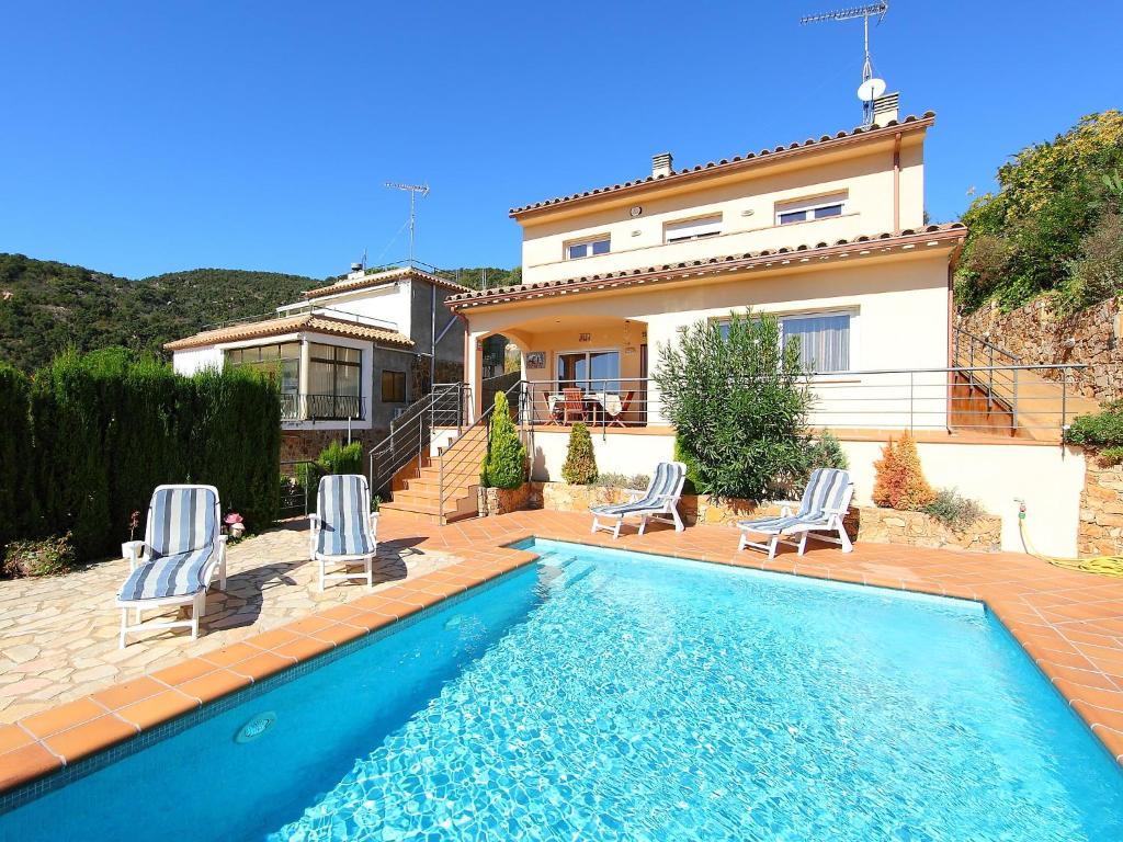 une maison avec une piscine en face d'une maison dans l'établissement Holiday Home Mas Ambros by Interhome, à Calonge