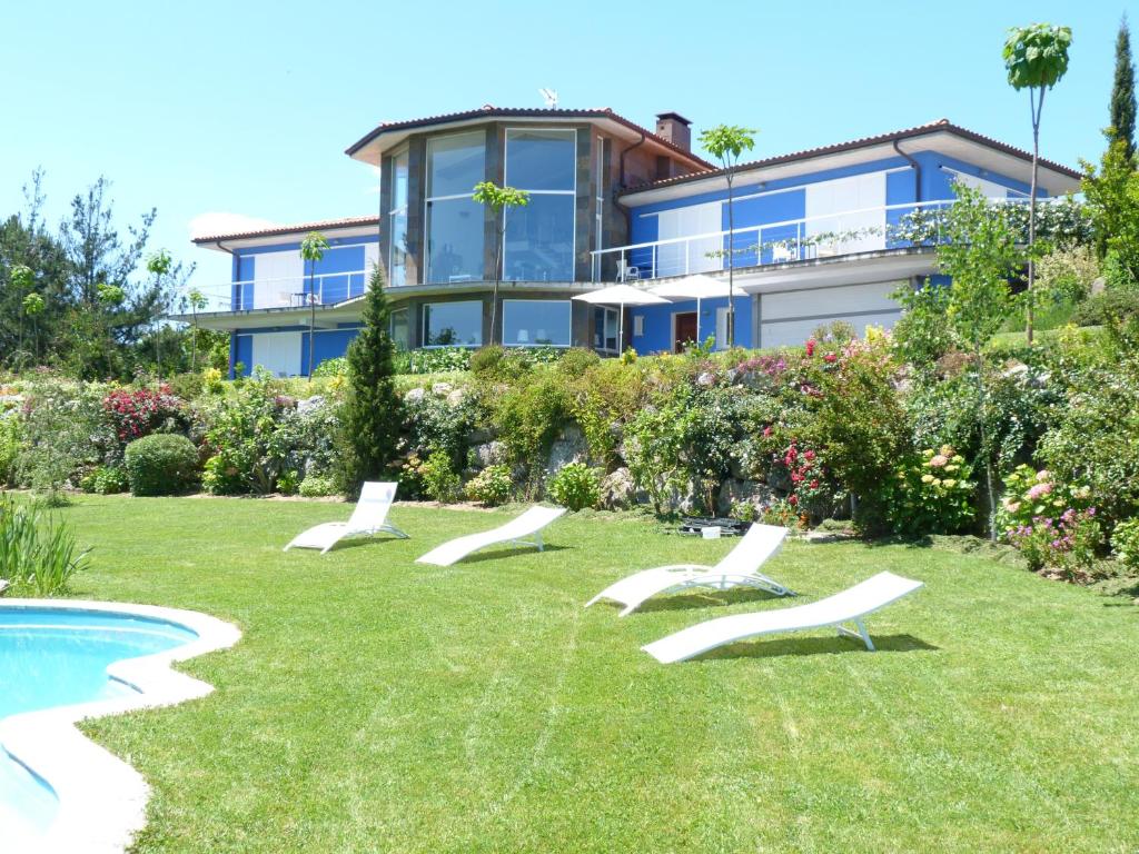 una casa con un patio con sillas y una piscina en Hotel Garazar, en Mendexa