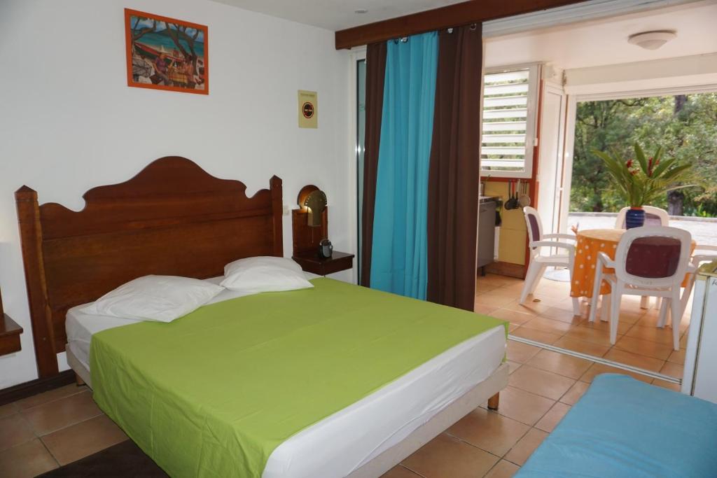 a bedroom with a bed and a table and chairs at Appartements Residence Mahoghany in Sainte-Anne