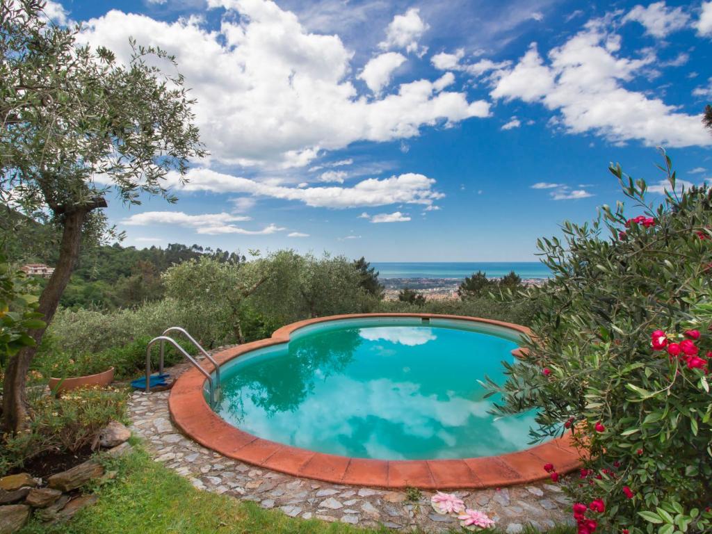 una piscina en un jardín con vistas al océano en Holiday Home Villa Poggiobello by Interhome, en Massa