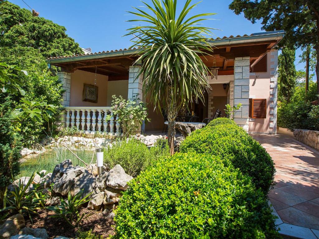 una casa con una palmera en el patio en Holiday Home Patrizia Classic, en Selce