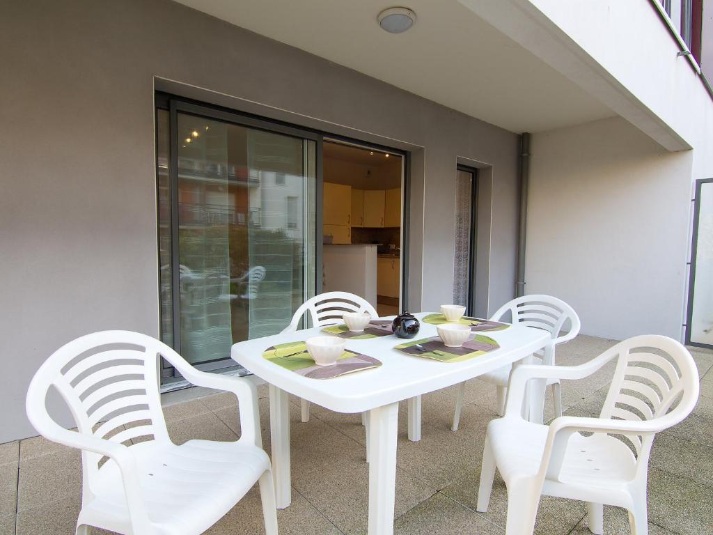 une table blanche et quatre chaises sur la terrasse dans l'établissement Apartment Quai Malo by Interhome, à Saint-Malo