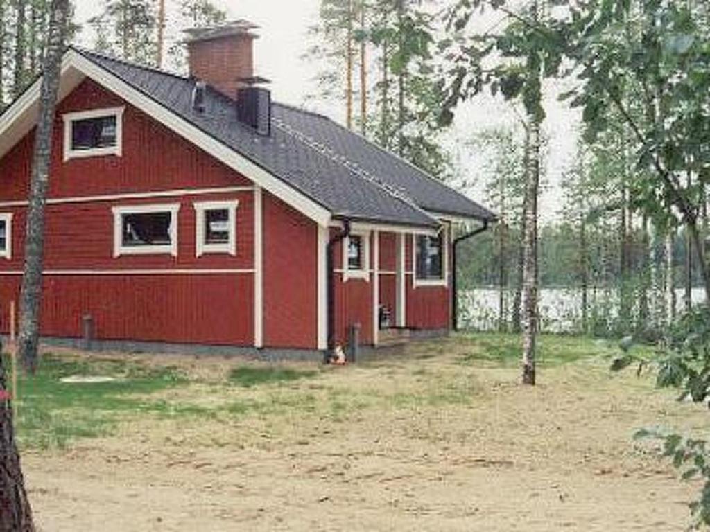 une maison rouge avec un chien devant elle dans l'établissement Holiday Home 6333 by Interhome, à Rantakylä