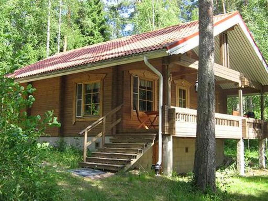 Cette petite maison en bois dispose d'une terrasse couverte et d'escaliers. dans l'établissement Holiday Home Mustikka by Interhome, à Röylä