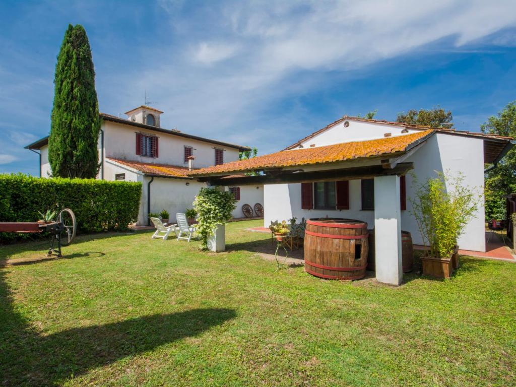 a house with a yard with a barrel at Holiday Home Casetta Ponticelli by Interhome in Lavaiano