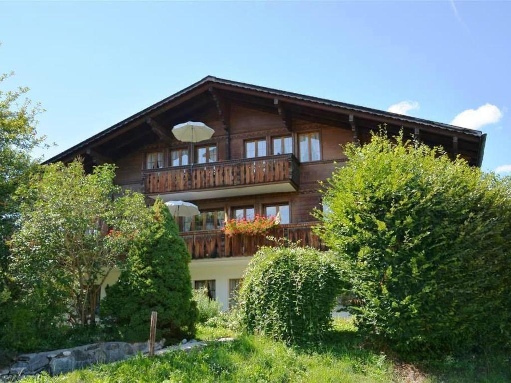 Cette grande maison en bois possède un balcon. dans l'établissement Apartment Abendrot by Interhome, à Gstaad