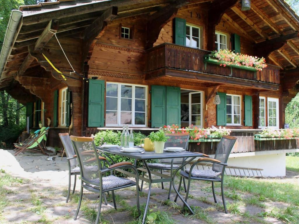 a table and chairs outside of a log cabin at Apartment Chalet Maru by Interhome in Lenk