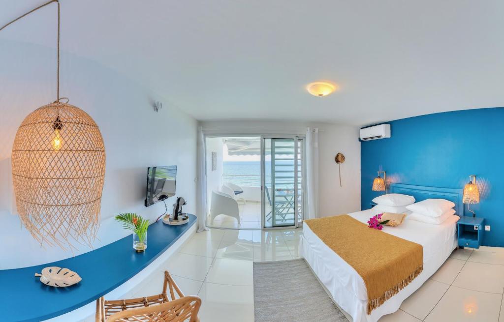 um quarto de hotel com uma cama e vista para o oceano em Hotel Pelican em Schœlcher