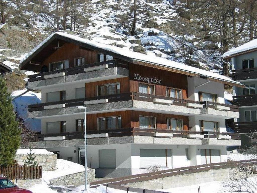 a large building with snow on top of it at Apartment Moosgufer by Interhome in Saas-Almagell