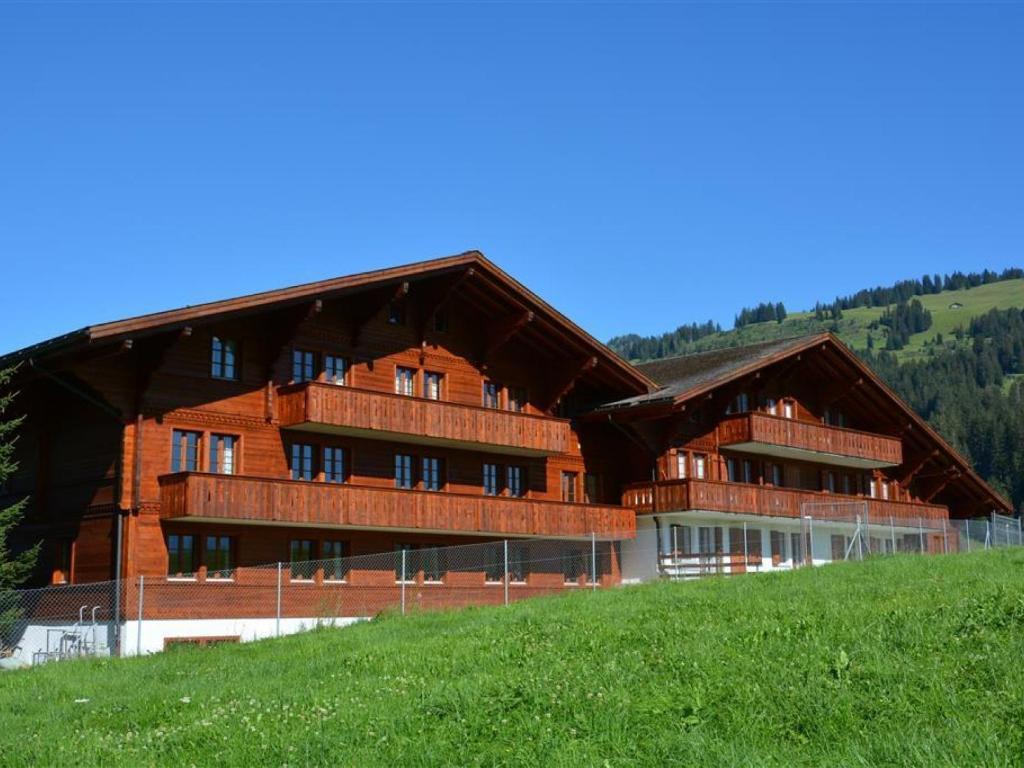 a large wooden building on top of a hill at Apartment Anne - Tiefparterre by Interhome in Gstaad