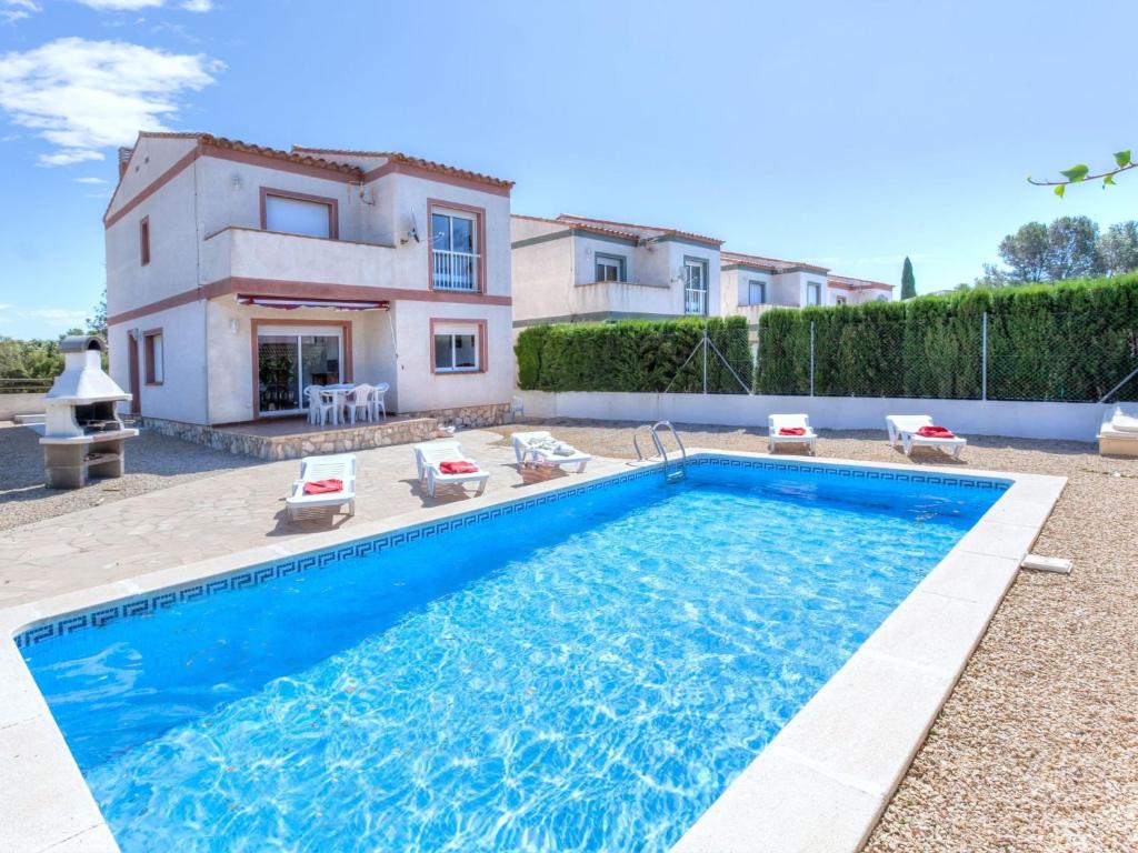 a villa with a swimming pool in front of a house at Holiday Home Villa Santa Marta I by Interhome in Les tres Cales