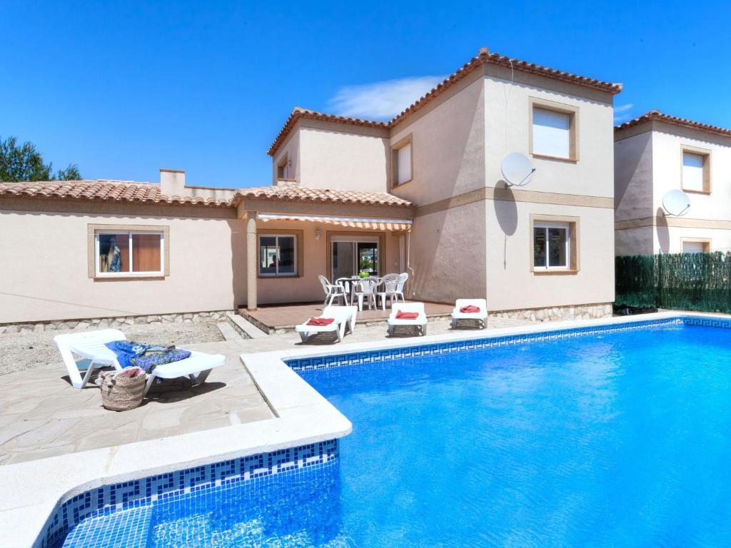 a villa with a swimming pool in front of a house at Villa Villa Mimosa I by Interhome in Les tres Cales