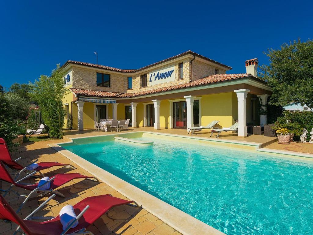 a swimming pool in front of a house at Villa de l'amour by Interhome in Orbanići