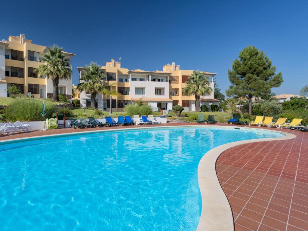 una piscina en un complejo con edificios de fondo en Apartment VistaMoura by Interhome, en Benfarras