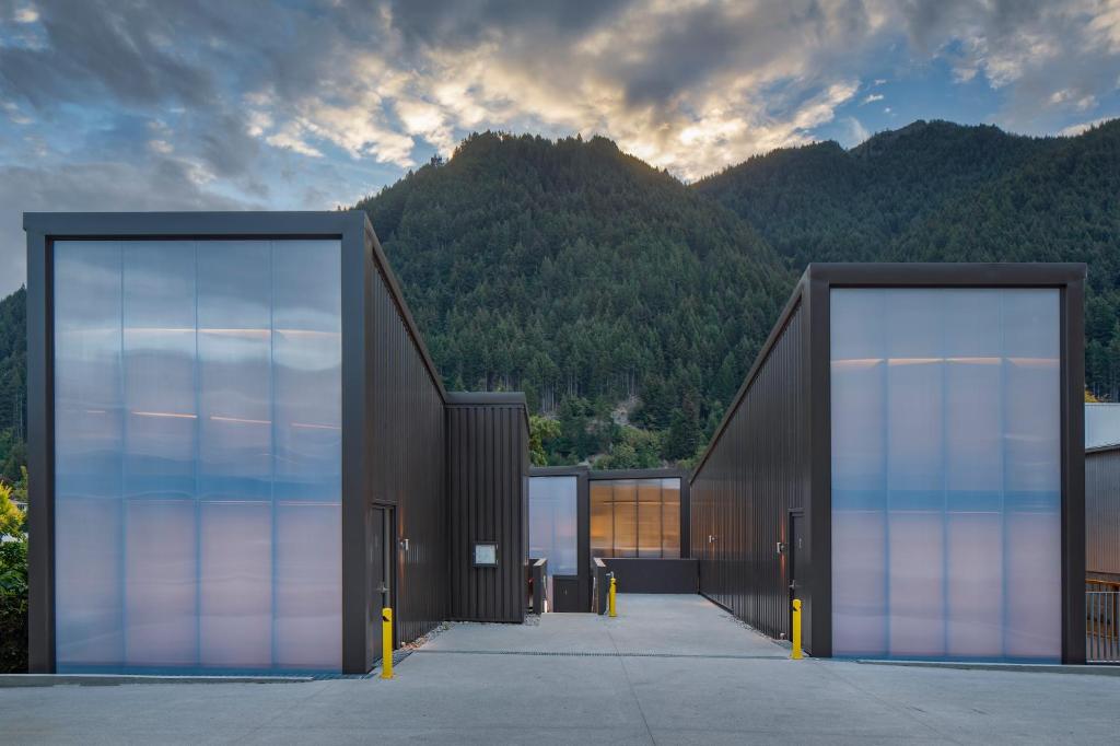 a building with two doors with mountains in the background at Koura Apartments Central Queenstown in Queenstown