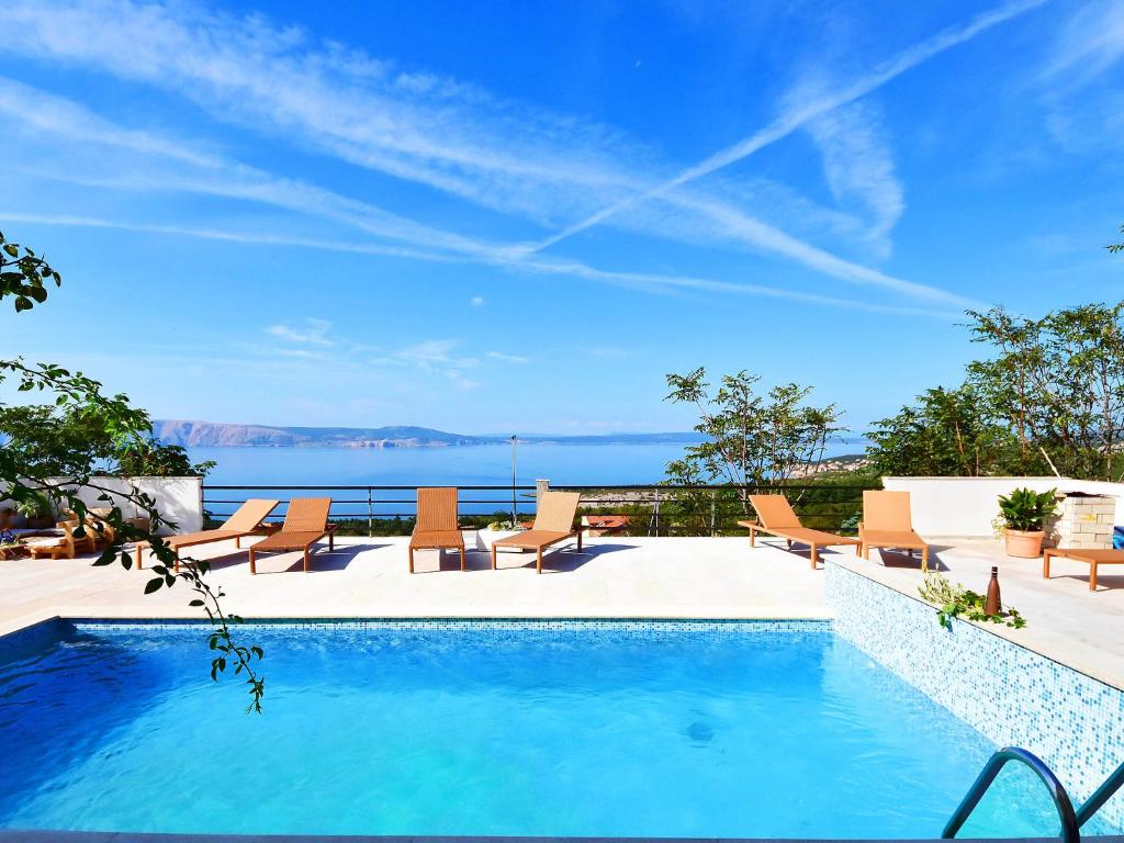 una piscina con sillas y vistas al agua en Holiday Home Stana by Interhome en Klenovica