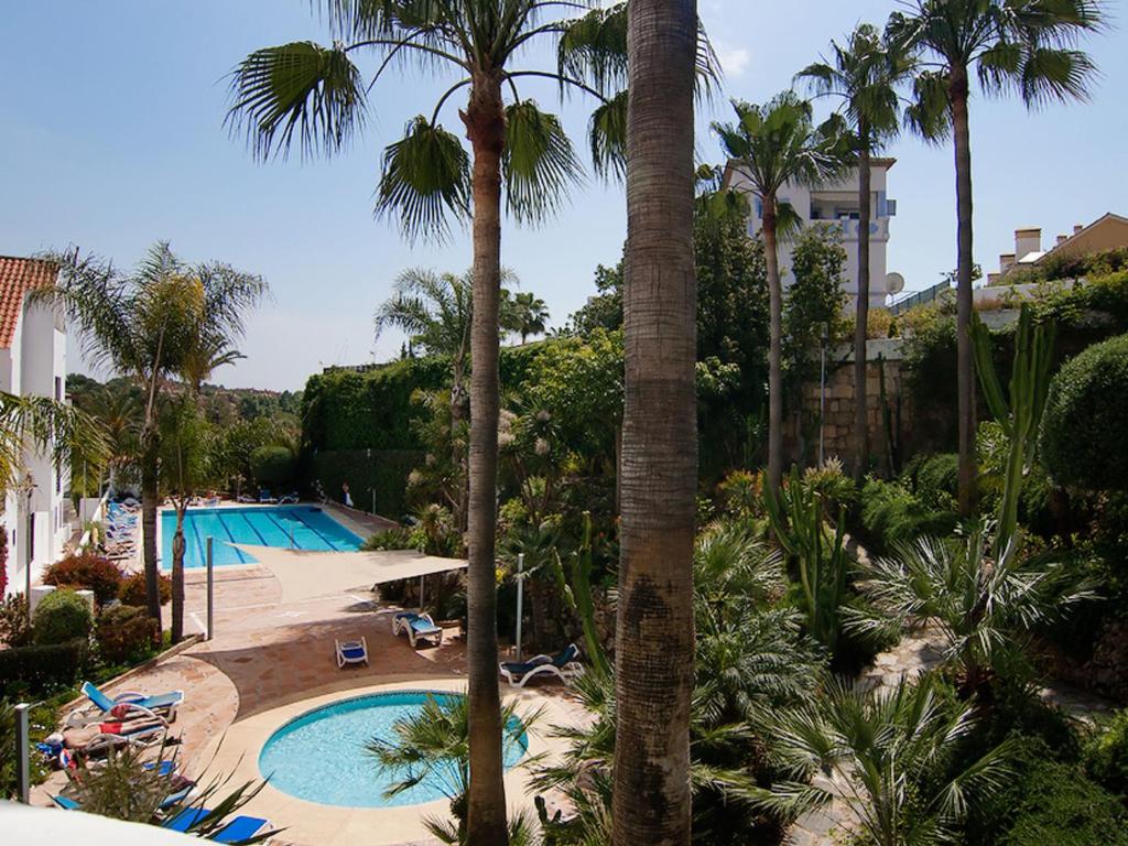un complexe avec une piscine et des palmiers dans l'établissement Apartment La Maestranza by Interhome, à Marbella