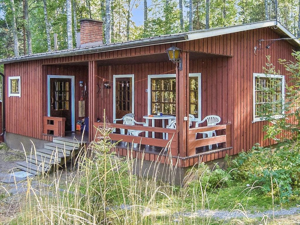 a red cabin with a table and chairs in it at Holiday Home 2234 by Interhome in Savonranta