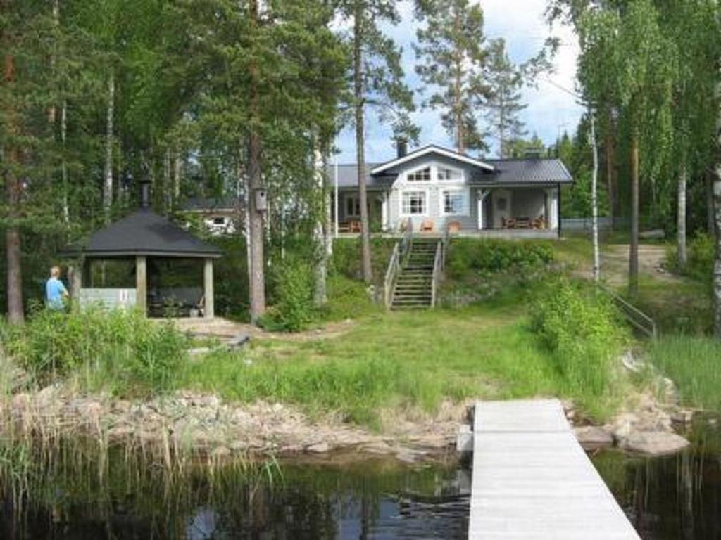 a house on the shore of a lake with a dock at Holiday Home Varvali by Interhome in Lahdenkylä