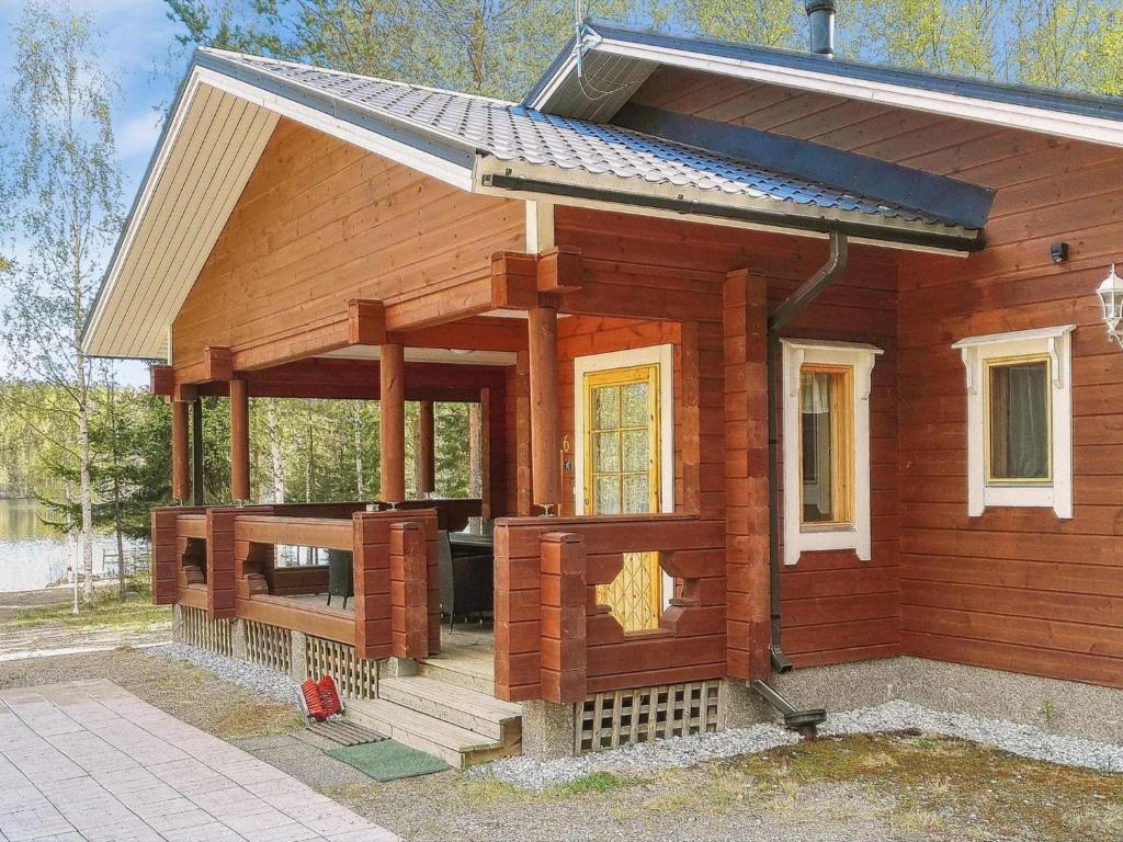 a small wooden house with a front porch at Holiday Home Villa kontio by Interhome in Savonranta