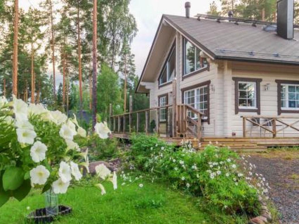ein Haus mit einem Garten mit Blumen davor in der Unterkunft Holiday Home Aurinko by Interhome in Holiseva