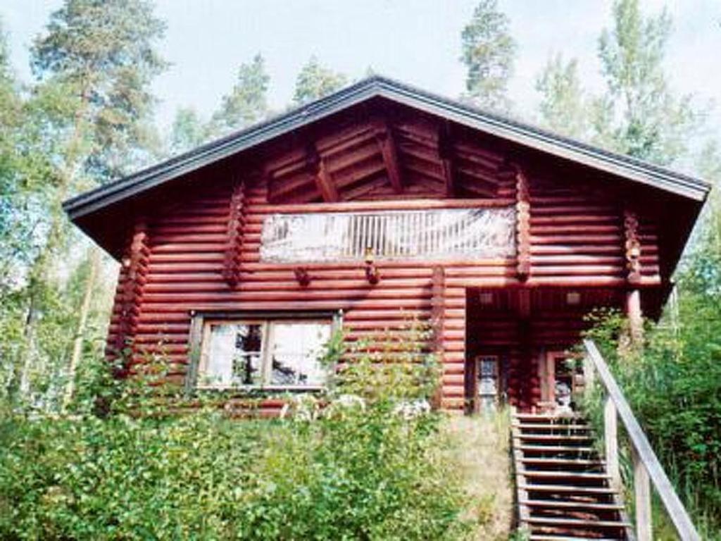 Holiday Home Harakanpesä by Interhome في Saalahti: كابينة خشب مع درج في غابة
