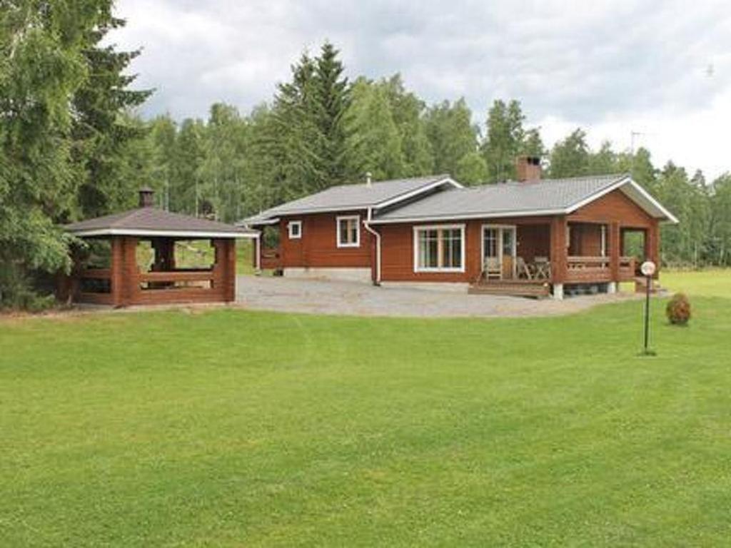 ein Haus in einem Garten mit grünem Rasen in der Unterkunft Holiday Home Petäjäinen by Interhome in Sipsiö