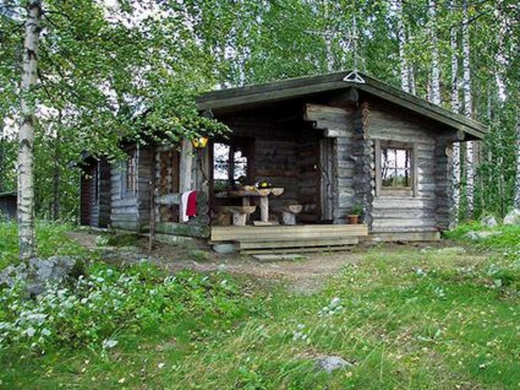 a small wooden cabin in the middle of a forest at Holiday Home Mäntyniemi by Interhome in Pätiälä