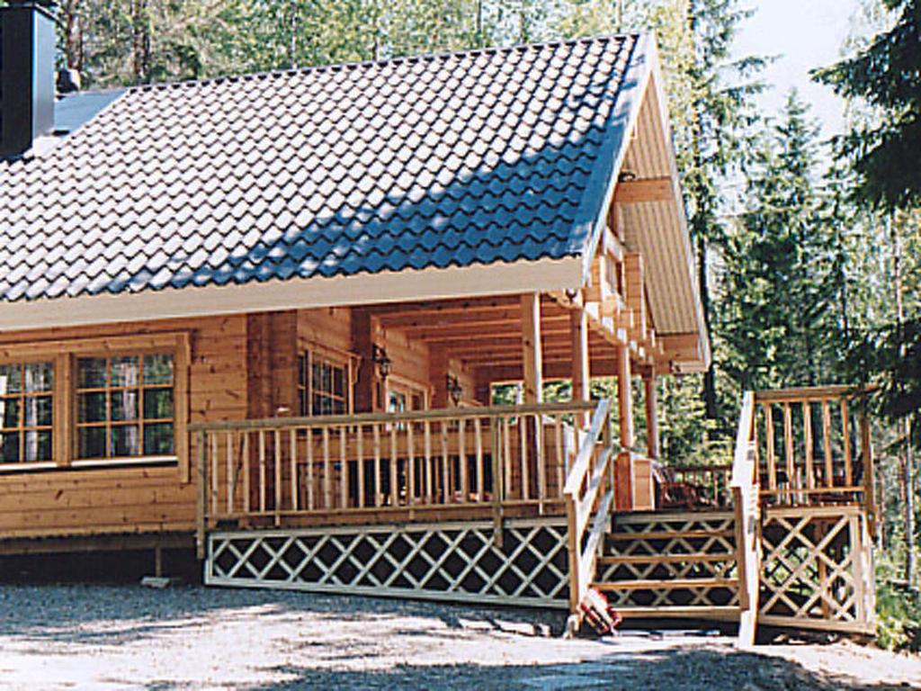 ein großes Holzhaus mit einer großen Terrasse in der Unterkunft Holiday Home Linnunlaulu by Interhome in Atro