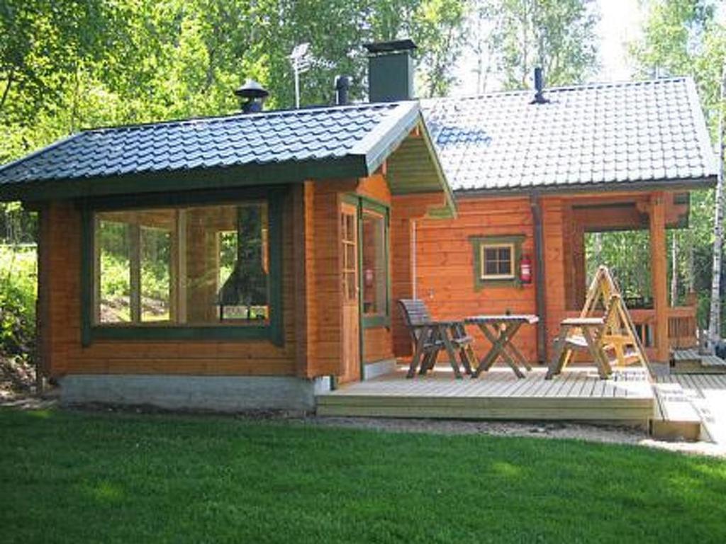 uma pequena cabana com um alpendre e uma mesa de piquenique em Holiday Home Rantatupa by Interhome em Hyyrylä