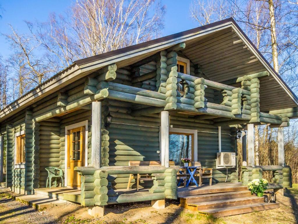 a log cabin with a porch and a deck at Holiday Home Karhulinna by Interhome in Miehoila